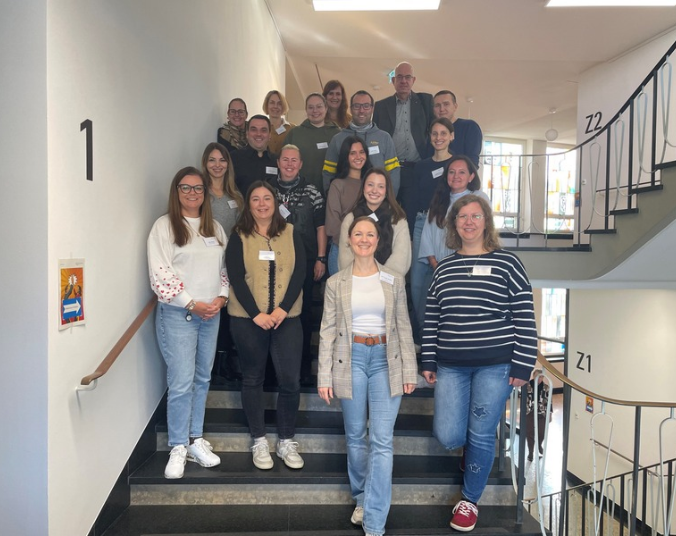 Ein Gruppenfoto der neuen Mitarbeitenden auf der Treppe im Rathaus.