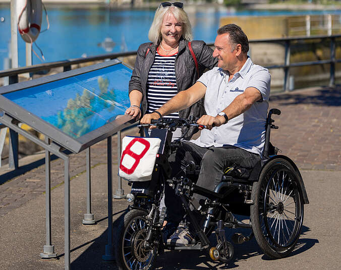 Mann im Rollstuhl und Frau blicken auf den Bodensee