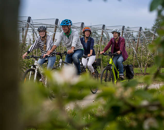 Ein Mann und drei Frauen fahren Fahrrad.