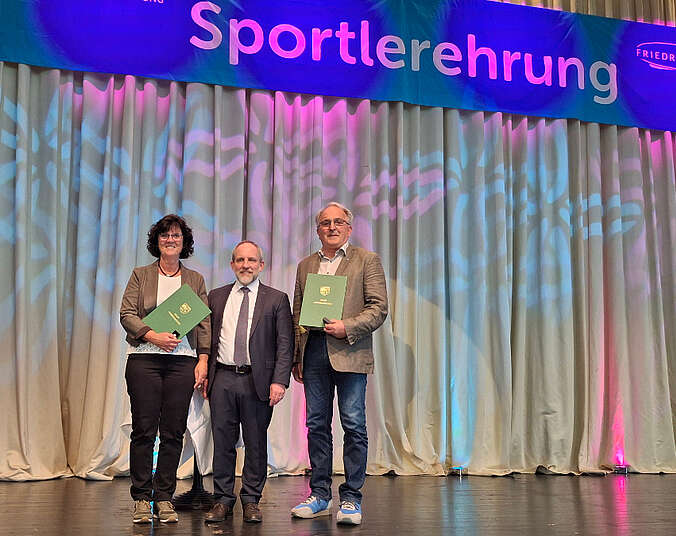 Die Preisträger halten Urkunde in den Händen.