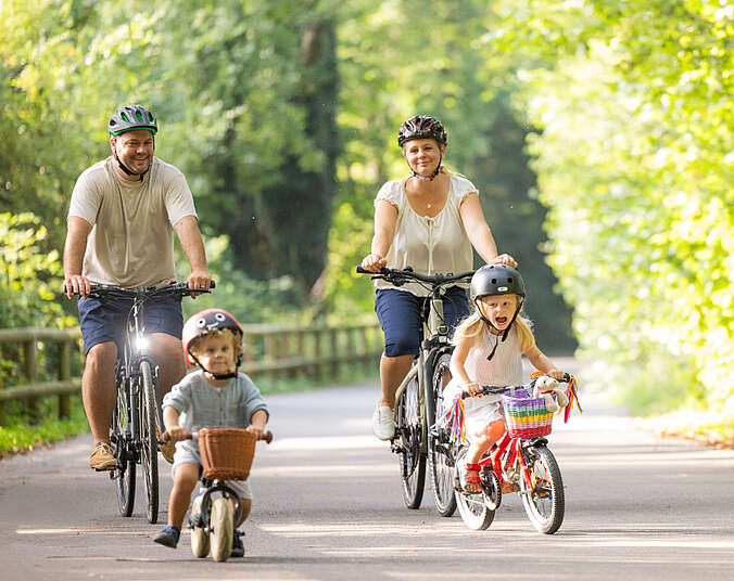 Ein Mann und eine Frau und zwei Kinder auf Fahrrädern.