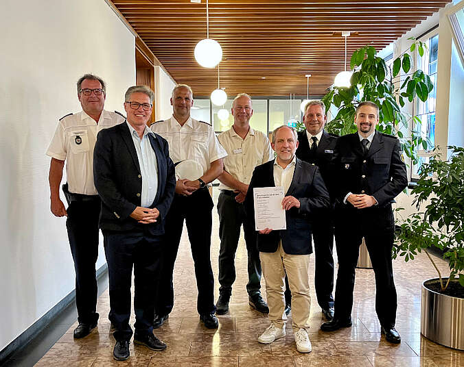 Gruppenbild: sieben Männer, Oberbürgermeister Simon Blümcke hält unterzeichnete Partnerschaft in der Hand