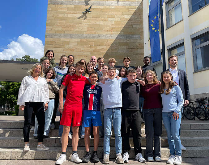 Schülerinnen und Schüler mit Lehrkräften und Brgermeister Hein stehen auf der Treppe vor dem Rathaus.