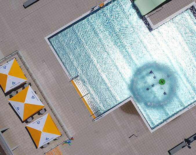 Schwimmbecken und Sonnenschirme von oben