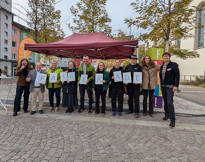 Frauen und Männer auf dem Adenauerplatz mit Tafeln Fairtrade