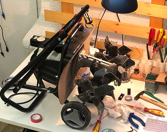 Defektes Kleinfahrzeug mit Rädern steht auf Tisch zum Reparieren.