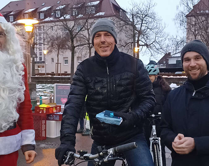Nikolaus mit zwei Männern und Fahrrad mit Licht