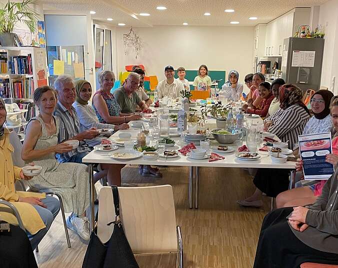 Viele Menschen an einem Tisch, (Foto: Stadt Friedrichshafen)
