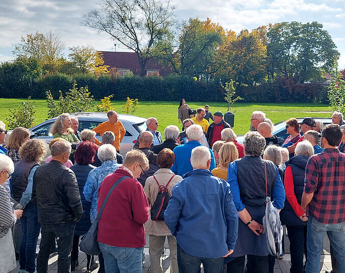 Eine Gruppe von Personen vor einer Wiese.