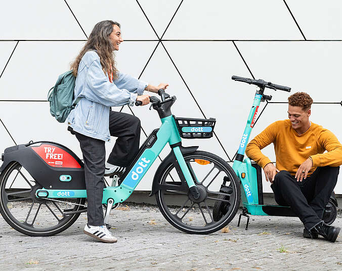 Frau mit Pedelec und Mann mit E-Scooter. (Foto: TIER Mobility SE)