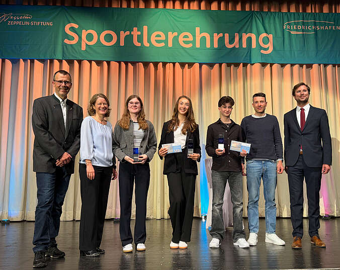 Männer und Frauen auf der Bühne.