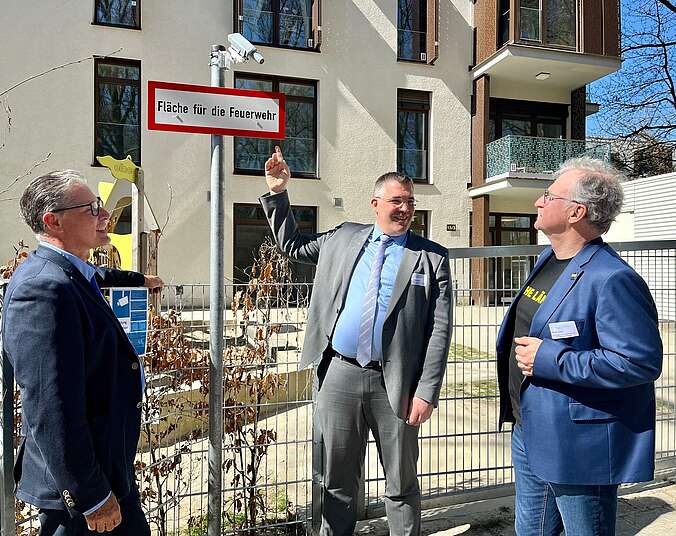 Drei Männer vor einer Rettungszufahrt mit Kamera-Sensor
